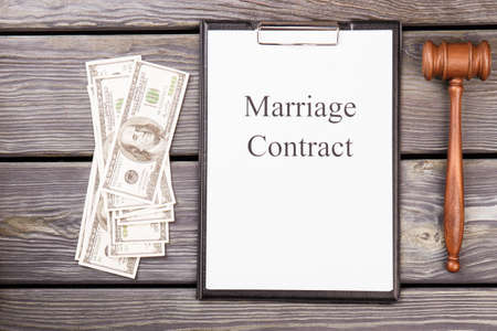 Top view marriage contract with dollars and gavel. Bribes and corruption concept.の写真素材