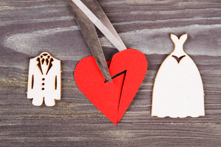 Broken heart with scissors. Divorse and heartbreak concept. Grey wood background.の写真素材