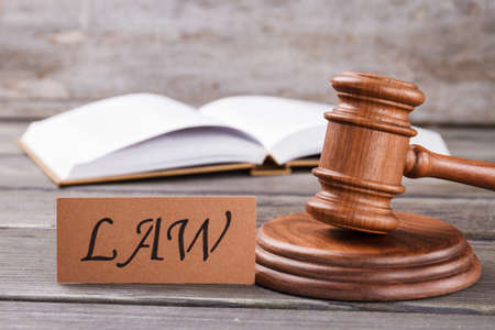 Word law and wooden gavel. Opened law book on the background.の写真素材