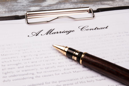 Close-up marriage contract with pen. Clipboard with printed agreement and pen for signature.の写真素材