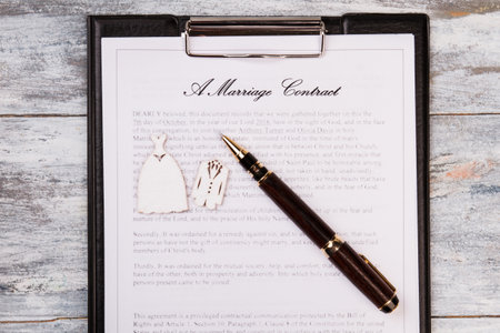 Marriage contract and pen top view. White wooden desk background.の写真素材