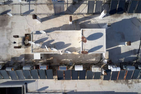 Solar panel and television antennas at the roof of building. Renewable and sustainable energy.の写真素材
