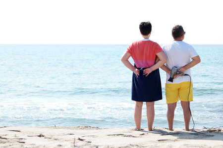 People with hairdressing accessories on seaside. Blue wavy sea in the background.
