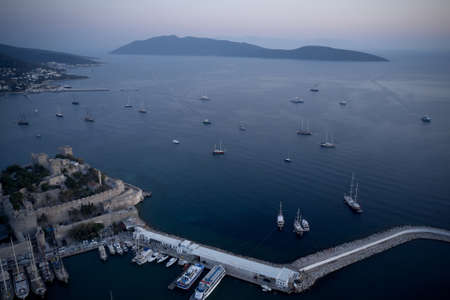 Bodrum bay and ancient castle of Saint Peter at the sunset. Boats floating on calm blue sea....