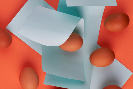 Chicken eggs and blue paper pieces.