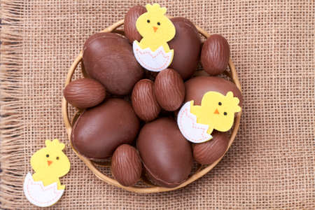 Pile of chocolate eggs and cartoon chicks.