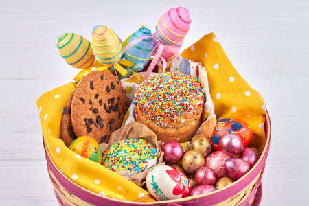 Festive bread and eggs. Wicker basket with festive eggs and easter cakes.