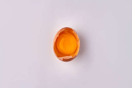 Raw cracked chicken egg with yolk.