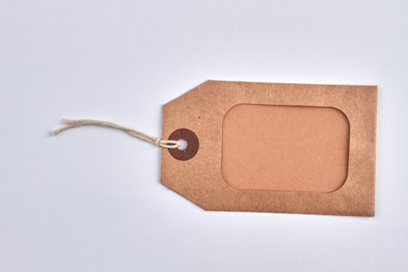 Blank brown cardboard price tag on white background.