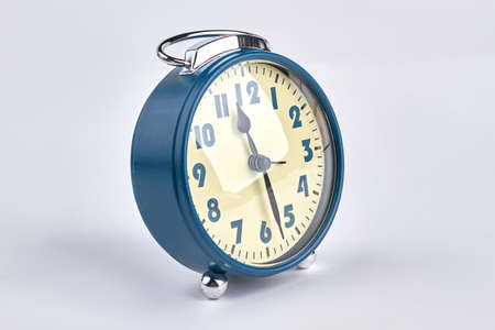 Blue old style alarm clock on white background.