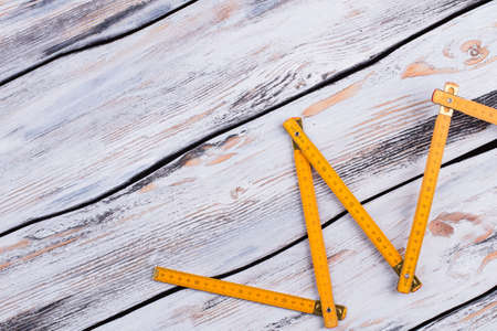Yellow folding ruler on gray wooden background.の写真素材