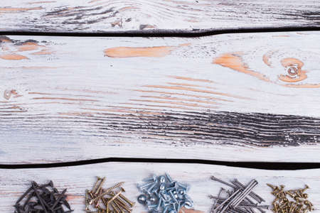 Various types of screws and nails on wooden background.の写真素材