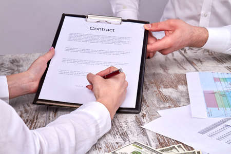 Businesswomans signing a contract. Big business deal.の写真素材