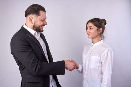 Smiling businessman handshaking with businesswoman isolated on white.の写真素材