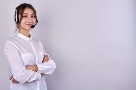 Portrait of cute girl with folded arms wearing headset.の写真素材