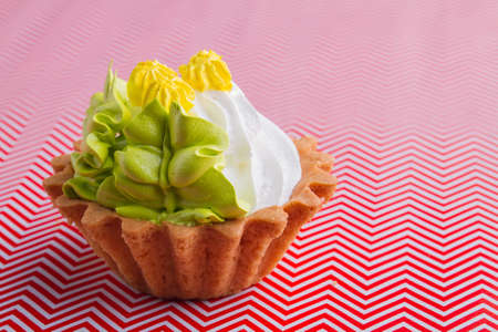 Close-up tasty sweet cupcake dessert on red and white background.