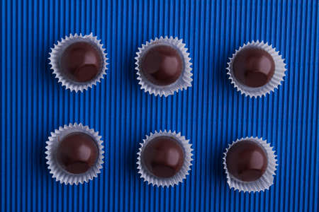 Set of six brown chocolate candies with wrap.