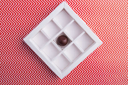Square-shaped chocolate box with one single candy.の写真素材