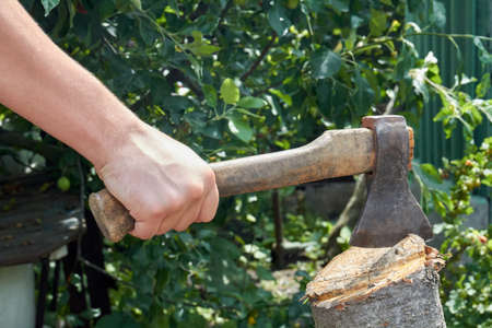 Close-up yog hand with axe cutting a log.の写真素材