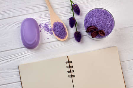 Notepad with purple spa stuff on white wooden table.の写真素材
