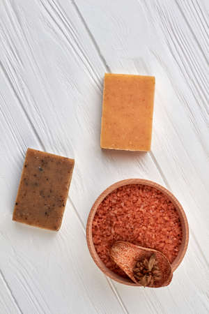 Cup of brown sea salt and handmade soap.