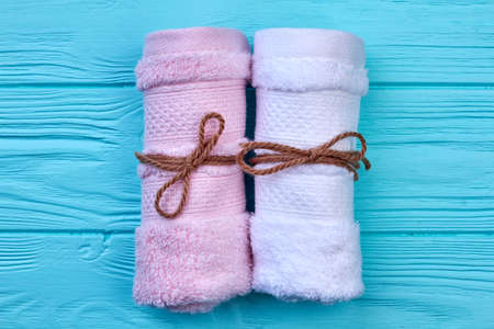 Rolled up colorful towels on blue wooden background.