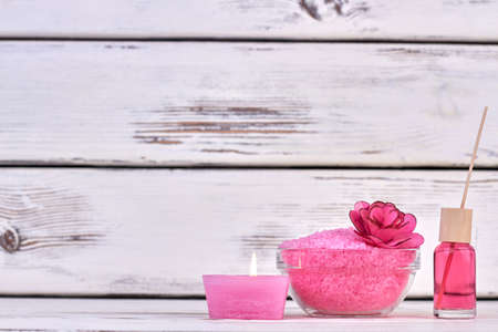 Still life burning candle with salt and bodycare lotion.