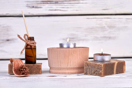 Soap with candles and oil bottle on white wooden background.の写真素材