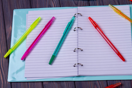 Open notepad with blank pages and many pens.の写真素材