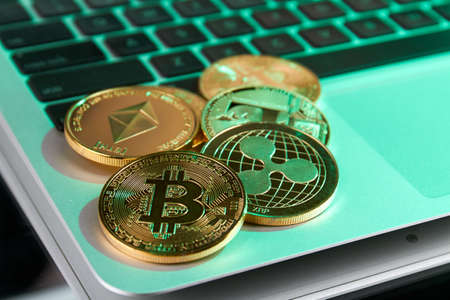 Golden cryptocurrency coins on the laptop close-up.