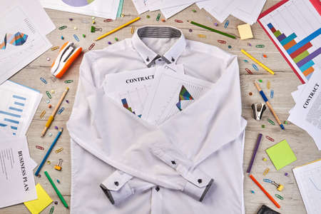 Top view white shirt with stationery workdesk stuff. Paperclips staplers pens etc.の写真素材