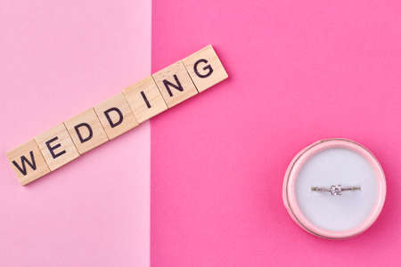 The inscription WEDDING on wooden cubes and gift box with ring. Marriage proposal concept.の写真素材