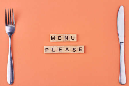 Menu please text written on wooden blocks. Fork and knife on table. Flat lay composition.の写真素材
