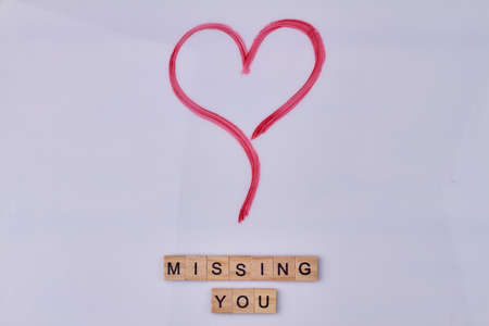 Red hand drawn heart and inscription missing you on vintage wooden cubes. Love and romance concept.