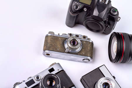 Many various different retro photo cameras on white background. Old-fashioned cameras closeup-up.
