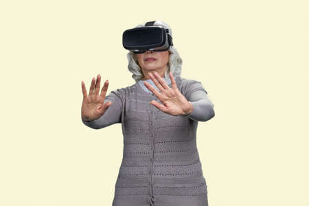 Old lady shocked experiencing virtual reality headset. Isolated on white background.
