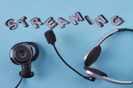 Web camera with headset and streaming word. Isolated on blue background.