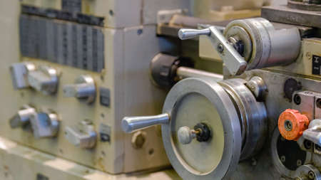 Old vintage lathe machine in the factory shop. Metalworking plant concept. Rotors with handles.