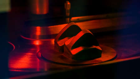 Close-up of metalwork machine components with red lightening. Abstract machinery steel detals in the...