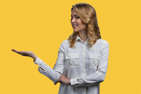 Pretty business woman showing at copy space while looking at her palm. Advertising and marketing concept.の写真素材