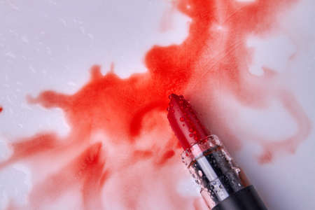 Top view red wet lipstick with wet stains. Makeup cosmetic accessory.の写真素材