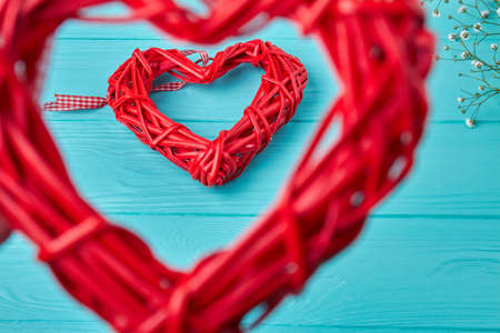 Close up red wickers heart frames on blue wooden desk. Valentines day concept.の写真素材