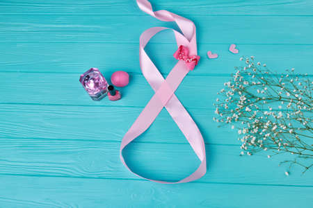 Flat lay top view womens day concept. Pink tape twisted in eight number. Female accessories and spring flowers.の写真素材