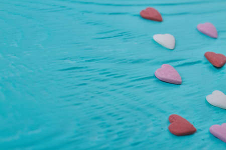 Close up colored candy hearts and copy space. Blue relief background.の写真素材
