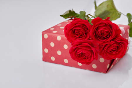 Bouquet of red roses on gift box. Isolated on white background.の写真素材