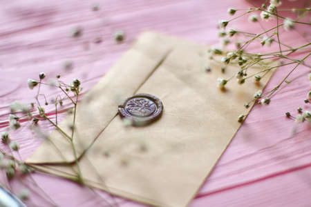 Close up envelope with brown wax seals. Pink wood background.の写真素材