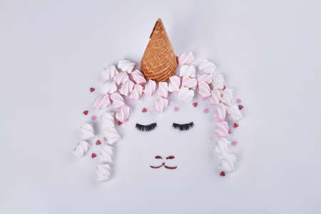 Ice cream cone and marshmallows represent hat and hair. Womans face with eyes closed.の写真素材