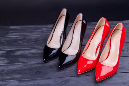 Pair of red and black high heel shoes. Shiny female footwear.の写真素材