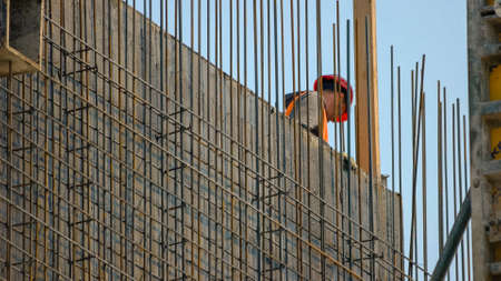 Worker on the skyscraper builiding construction site. Blue sky background.の写真素材