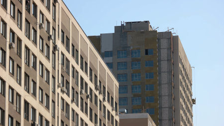 Building construction of high-rise skyscrappers with installed windows. New or forbidden buildings.